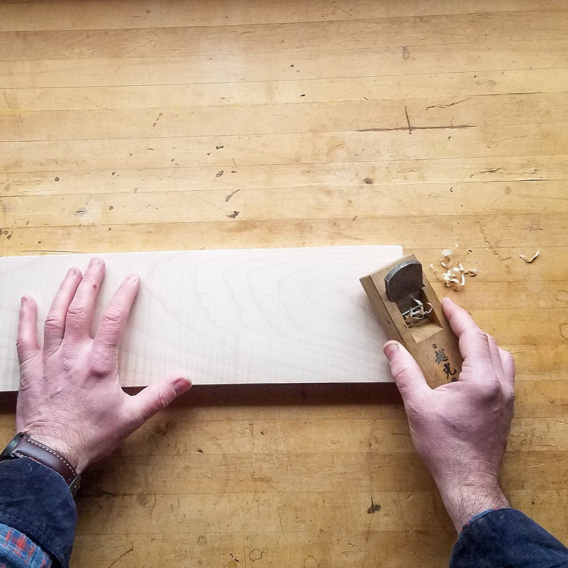 a traditional Japanese block plane is used by the expert furniture maker at Mokuzai Furniture to detail the ends of a shelf for a narrow long console table