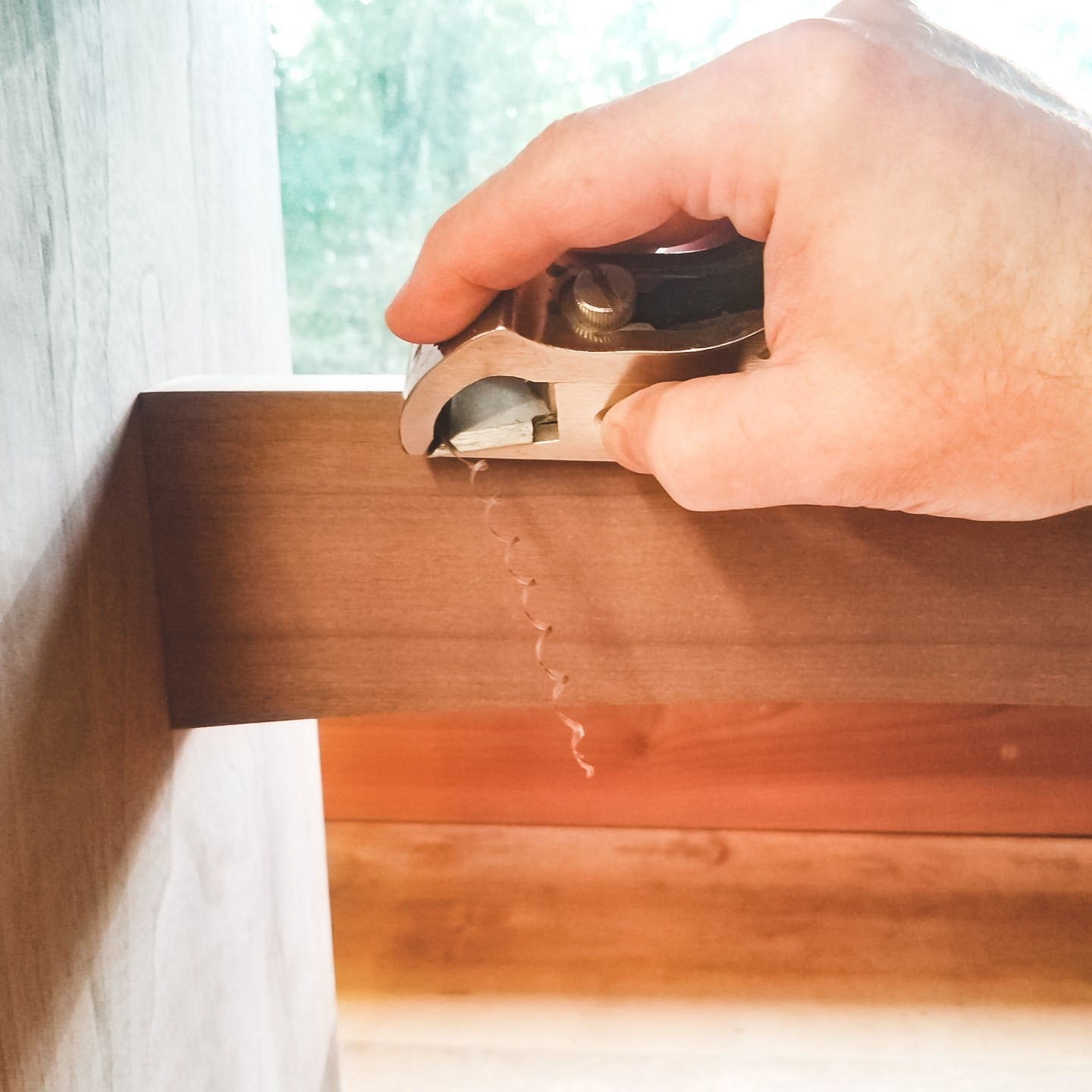 furniture maker details the stretcher of a modern wood entryway bench at Mokuzai Furniture