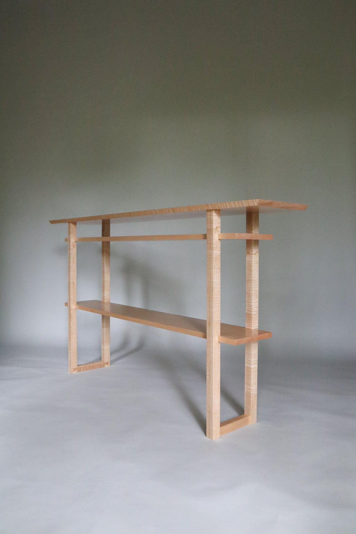 A unique tiger maple hallway console table with shelves by Mokuzai Furniture. Our narrow modern console tables add beauty to narrow spaces like hallways and entryway decor.