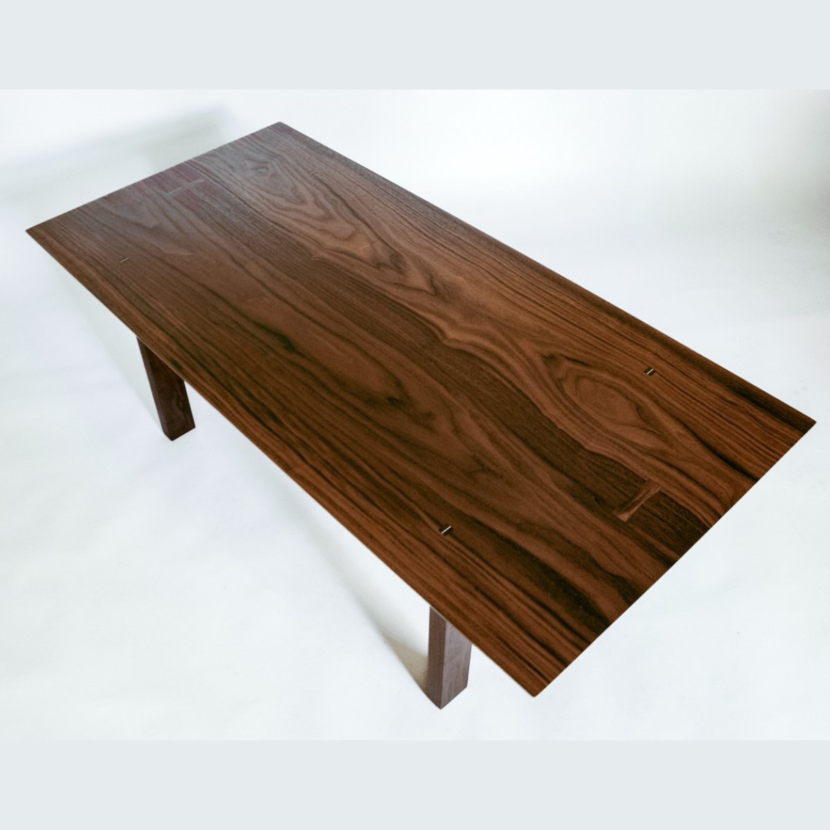 Stunning solid walnut coffee table with modern design lines from Mokuzai Furniture.