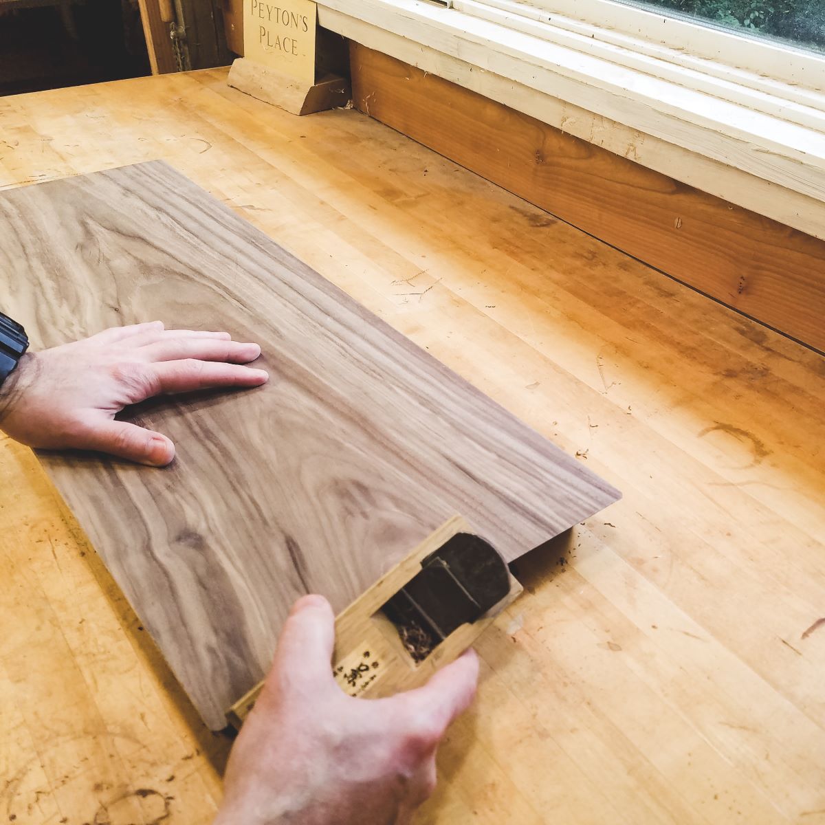 furniture maker cuts ends of a modern wood entryway bench at Mokuzai Furniture