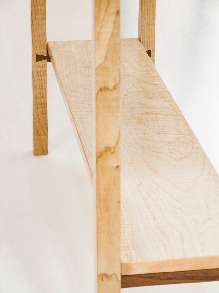 contrasting walnut dovetail rails are the supports for the shelf of this narrow console table