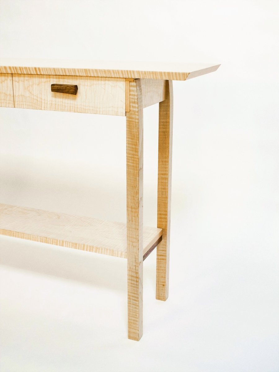 a narrow table with three drawers and a shelf for display