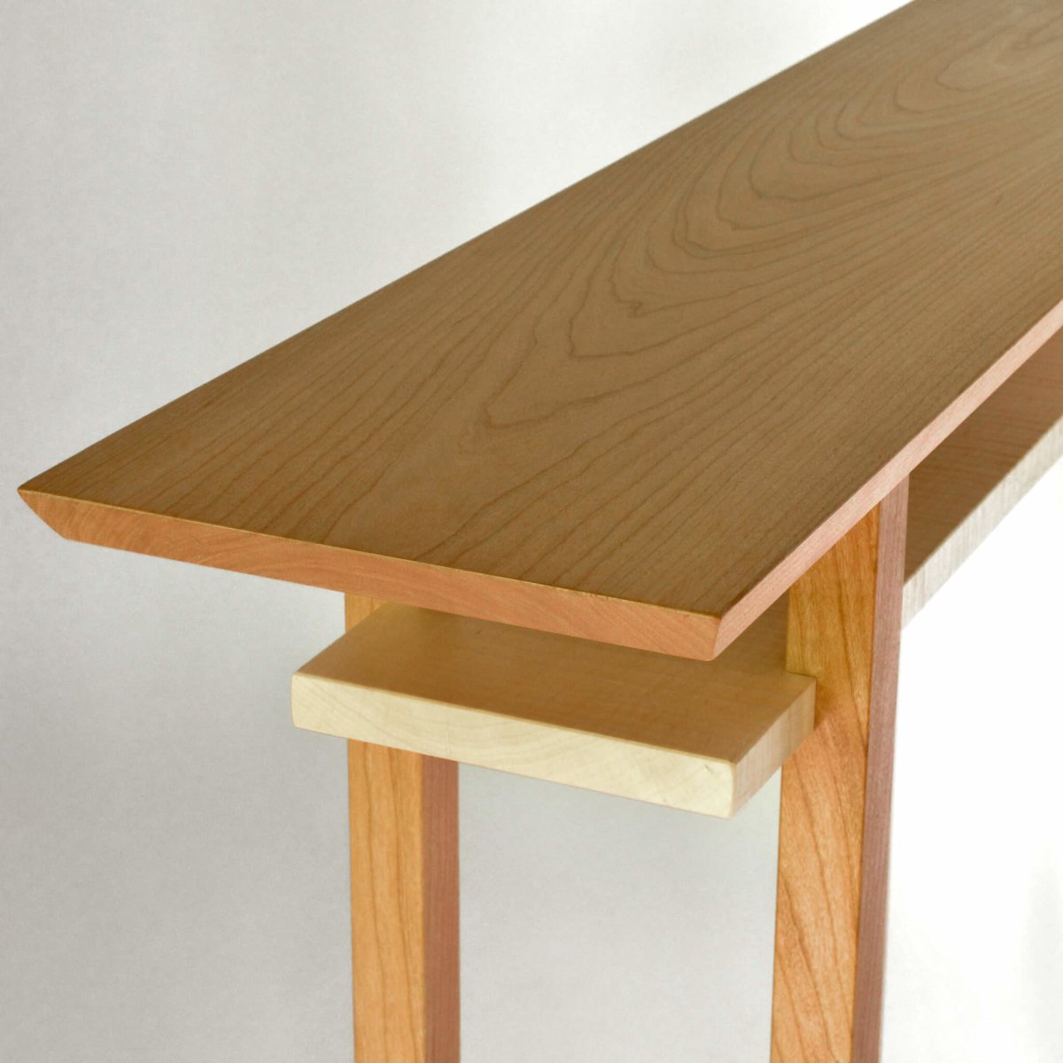 This narrow console table with shelf is made from cherry and tiger maple. Modern wood furniture designs by Mokuzai Furniture