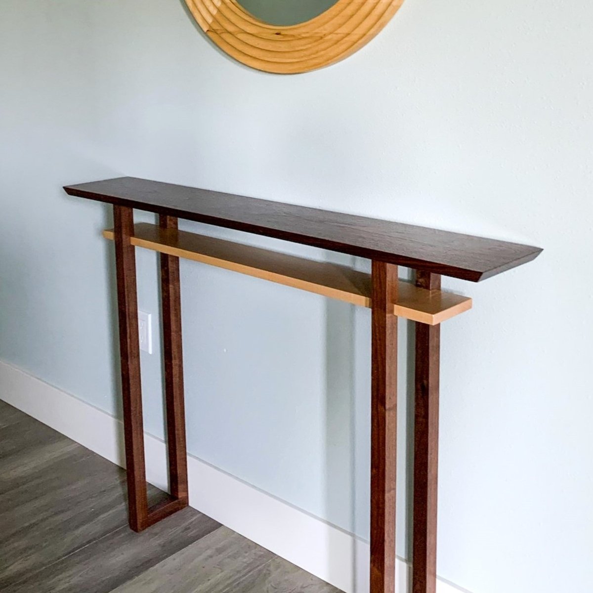 A narrow walnut console table for a modern entryway by Mokuzai Furniture