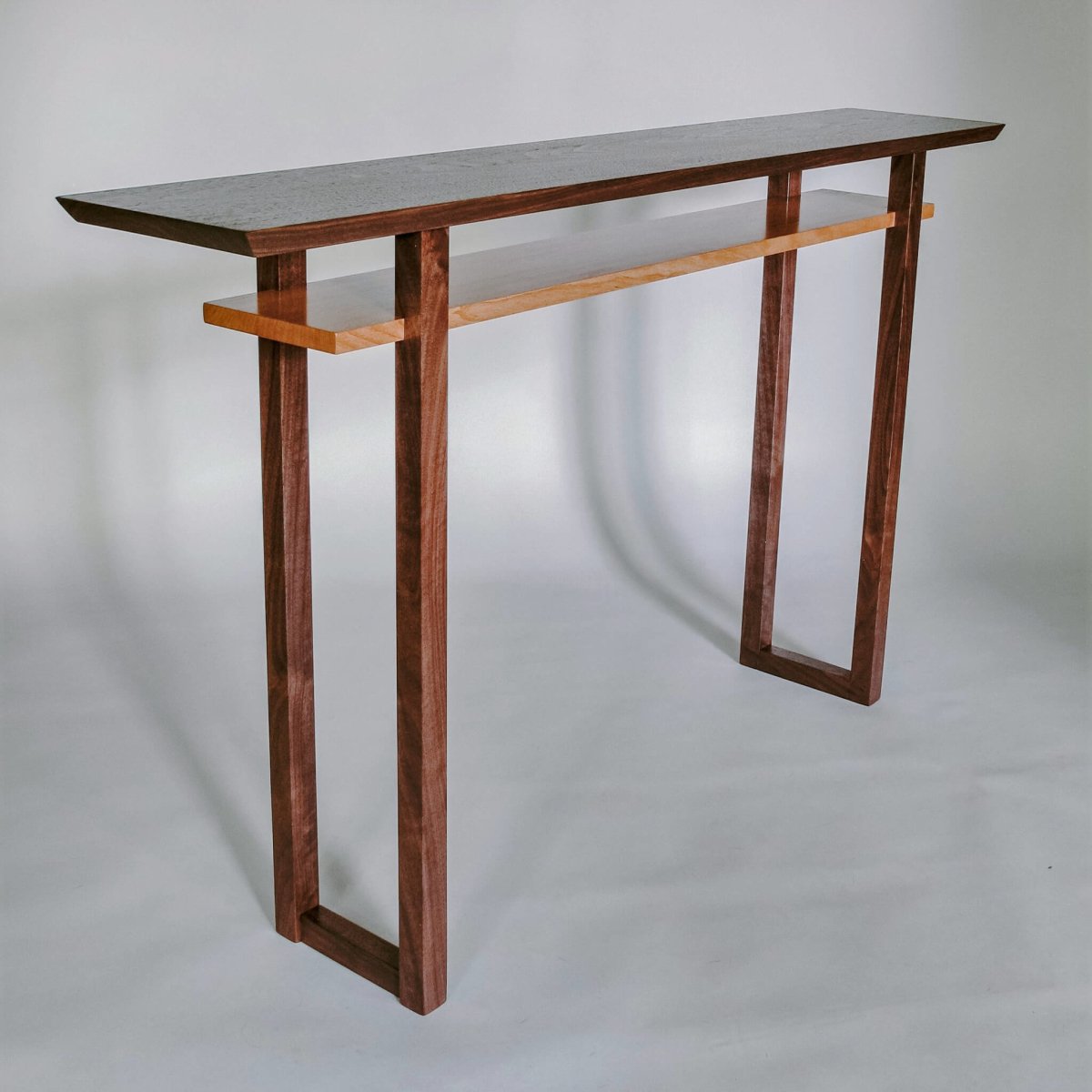 A walnut wood console table with cherry shelf. A modern wood furniture design from Mokuzai Furniture