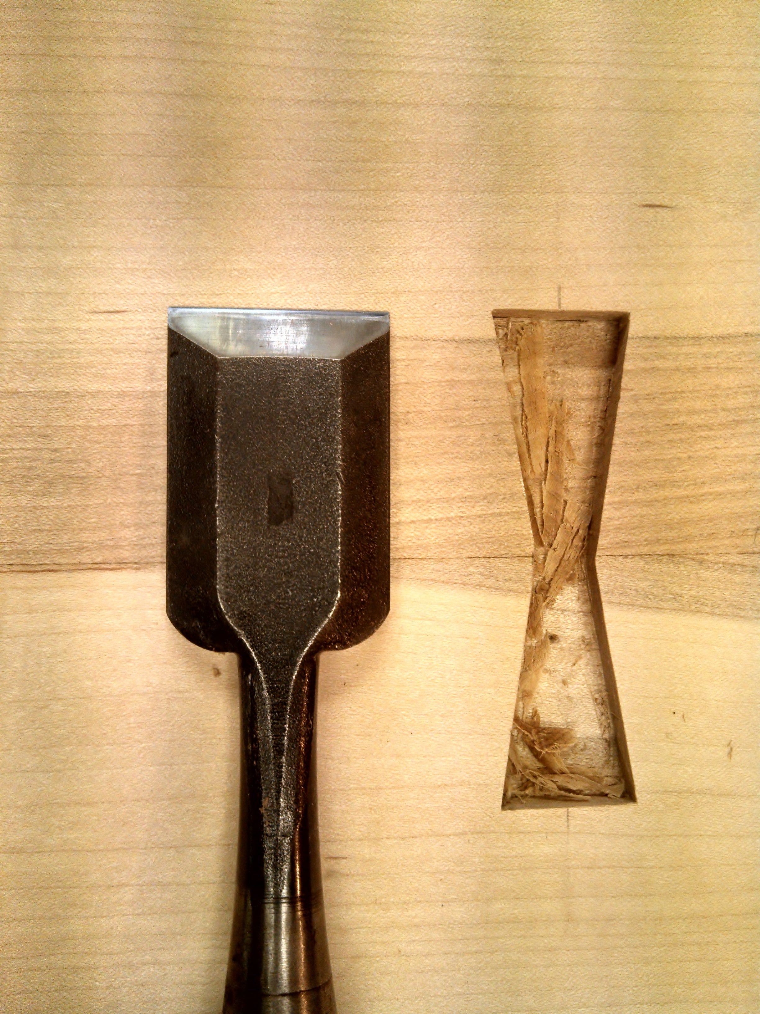 A chisel is used to cut the space for a butterfly key inlay in a contemporary side table from Mokuzai Furniture.
