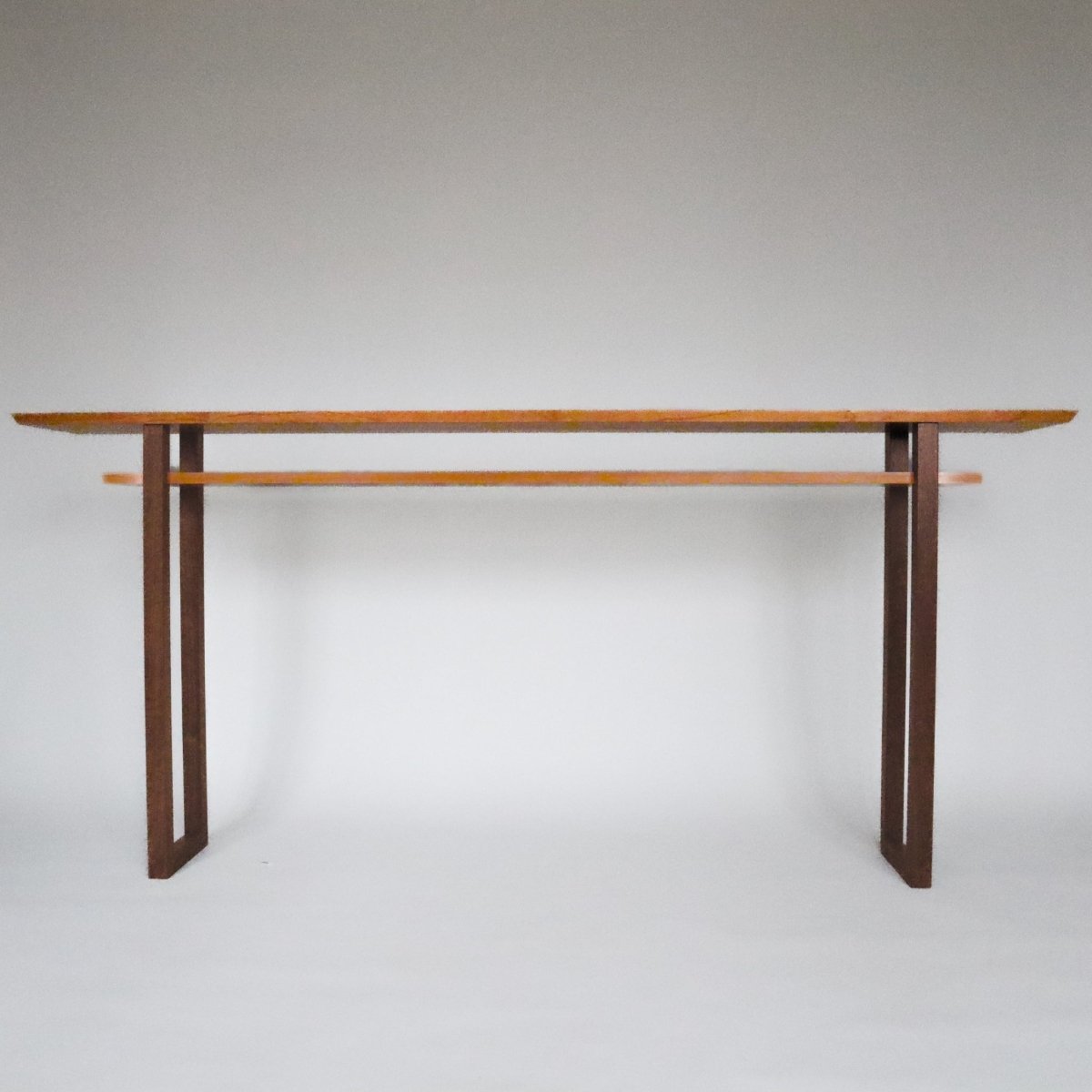 72 inch long narrow console table with cherry tabletop and shelf and contrasting walnut legs, created by Mokuzai Furniture.