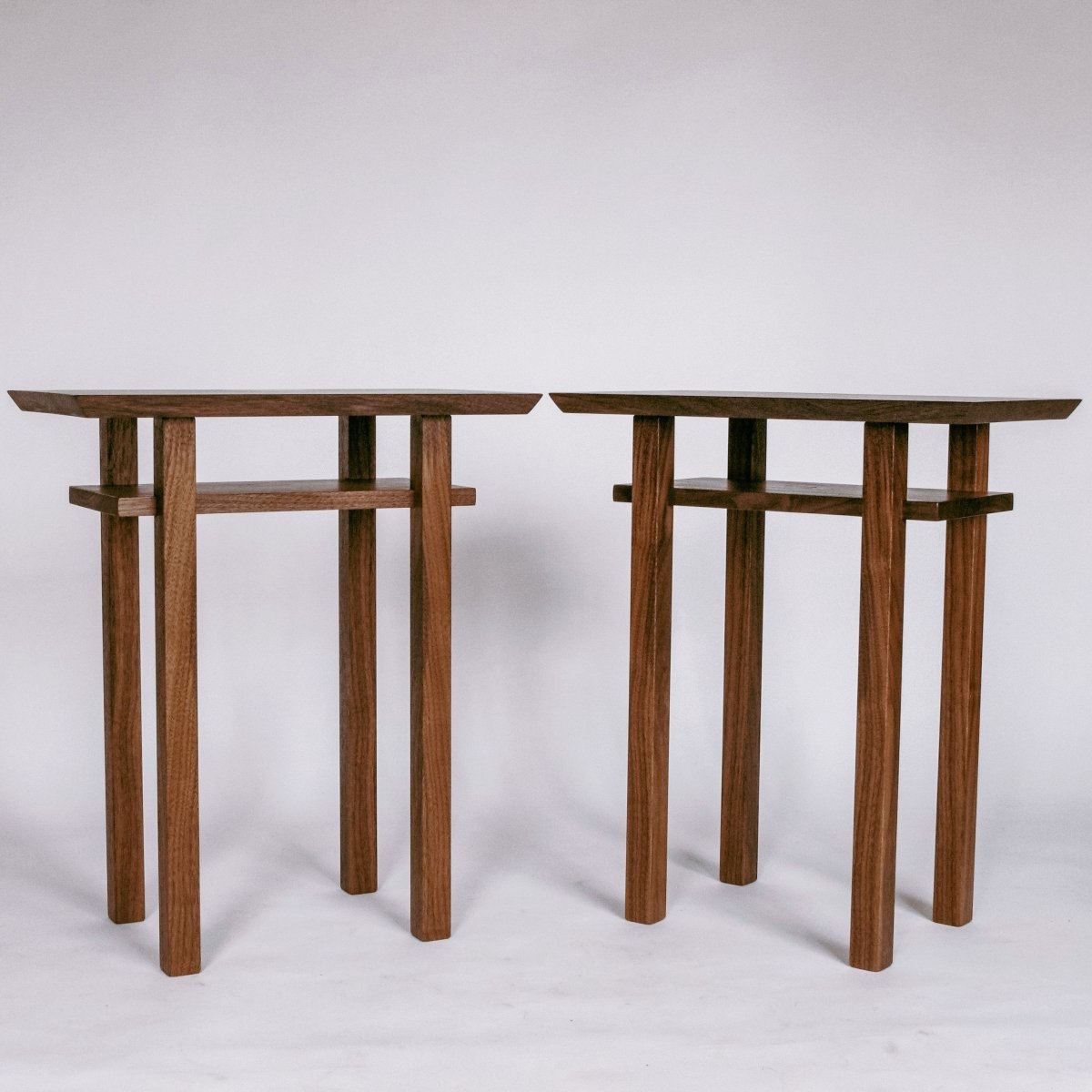 A pair of small end tables handmade from solid walnut by Mokuzai Furniture.