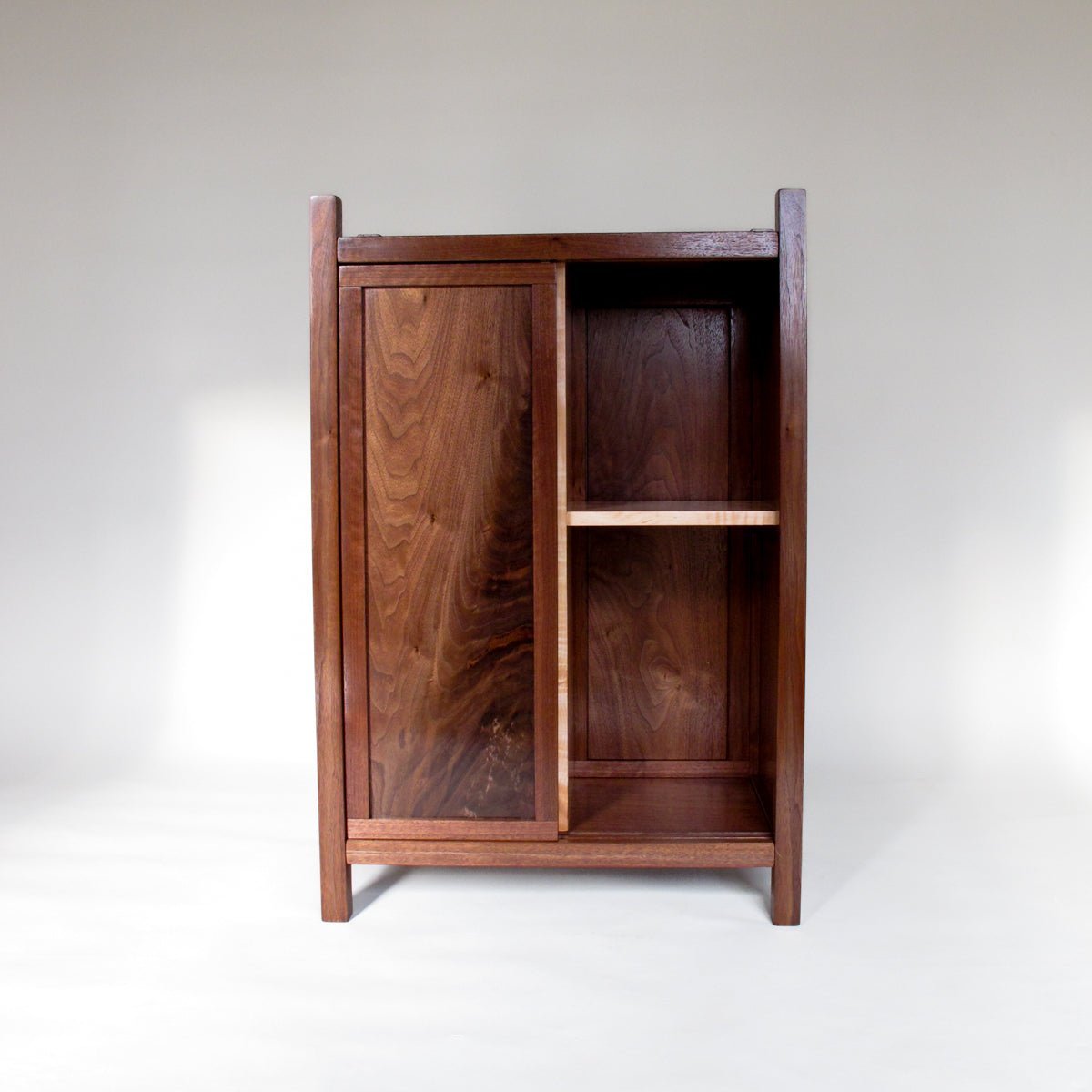 This bar cabinet with wine storage has a sliding door by Mokuzai Furniture.