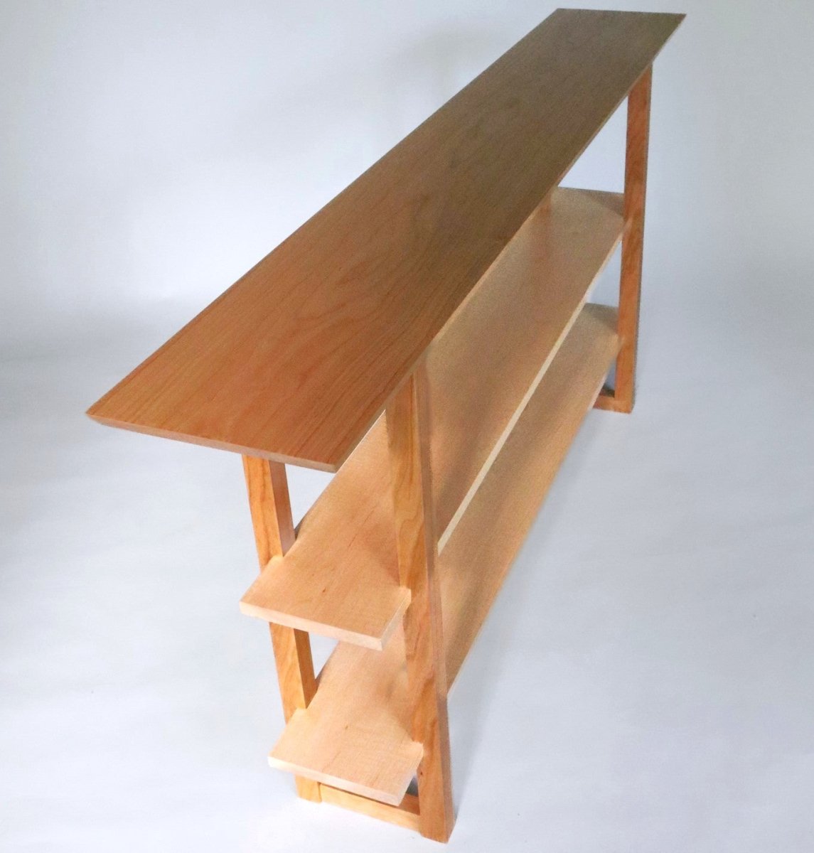 A cherry wood console table that is narrow for hallways and entryways by Mokuzai Furniture.