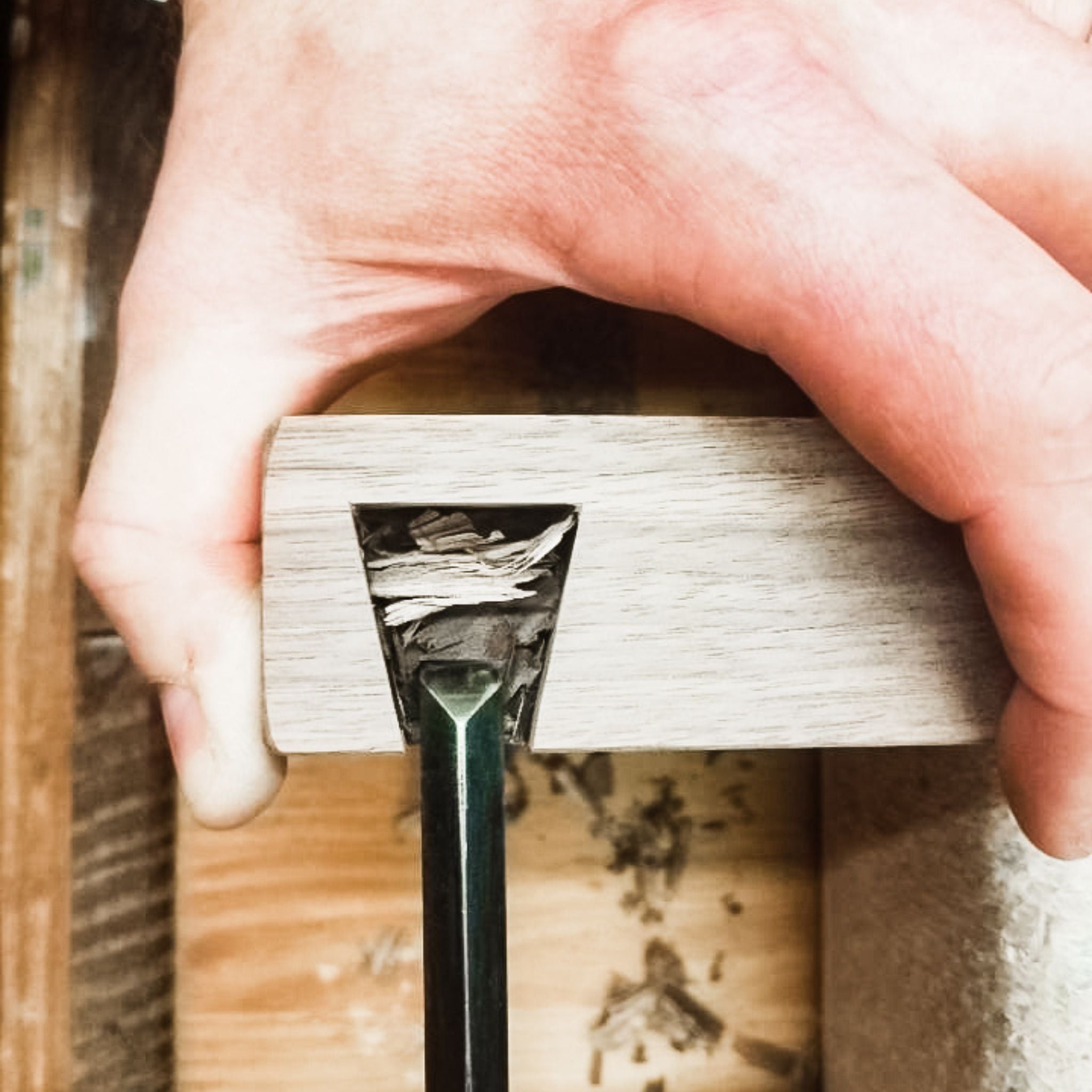 The furniture maker chisels dovetails for the feet of a modern walnut console table at Mokuzai Furniture.