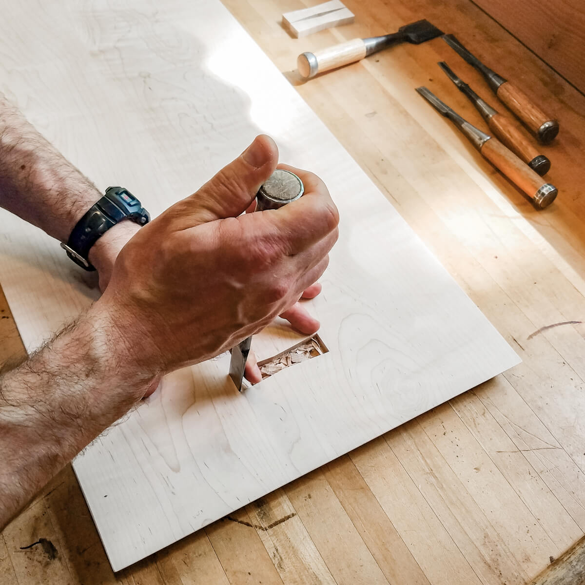 custom furniture maker cuts butterfly details in top of modern wood bench at Mokuzai Furniture