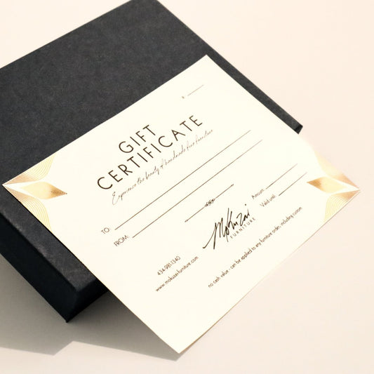 Gift certificate for custom wood furniture with gold accents on a navy blue box.