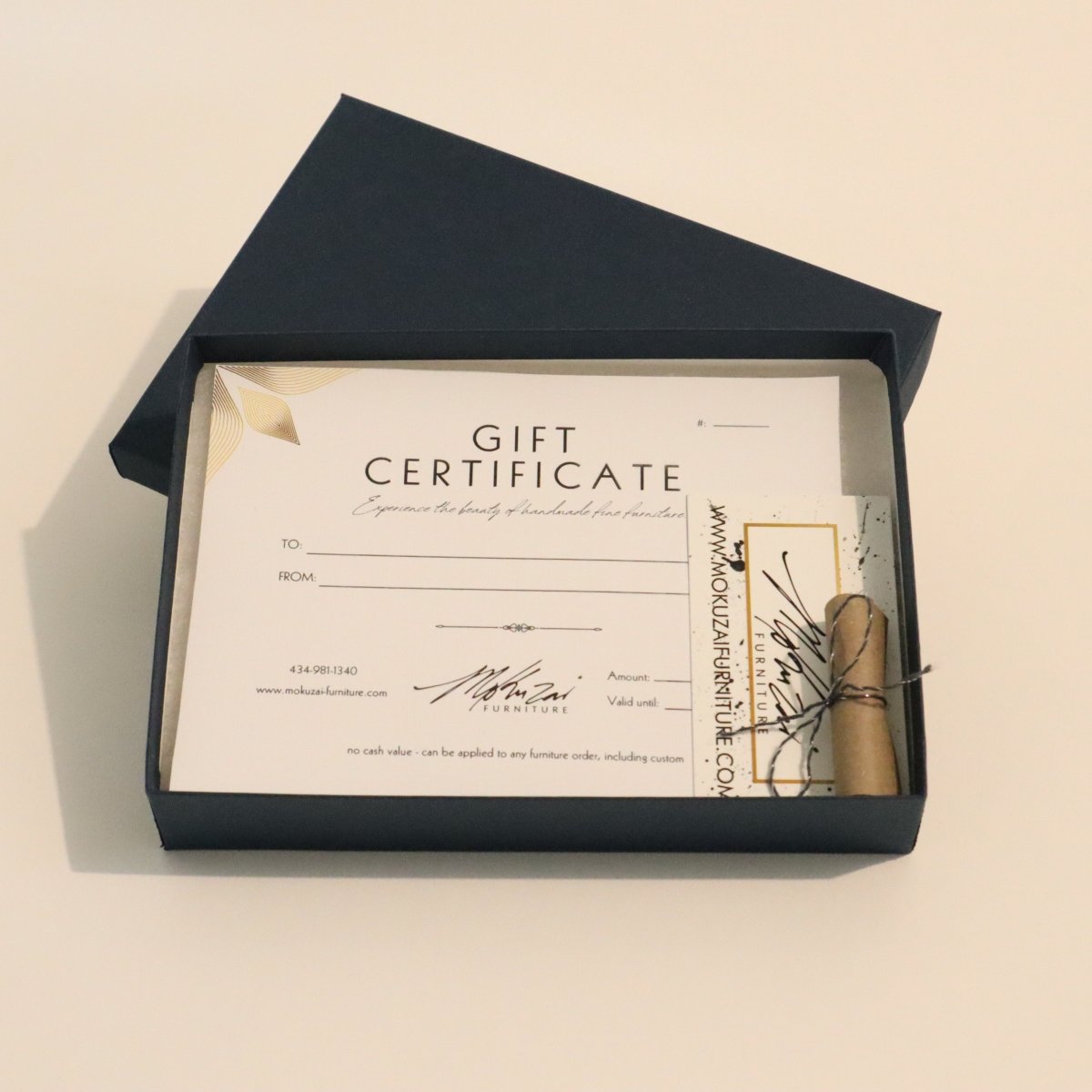 Gift certificate in a navy blue box for luxury wood furniture from Mokuzai Furniture.