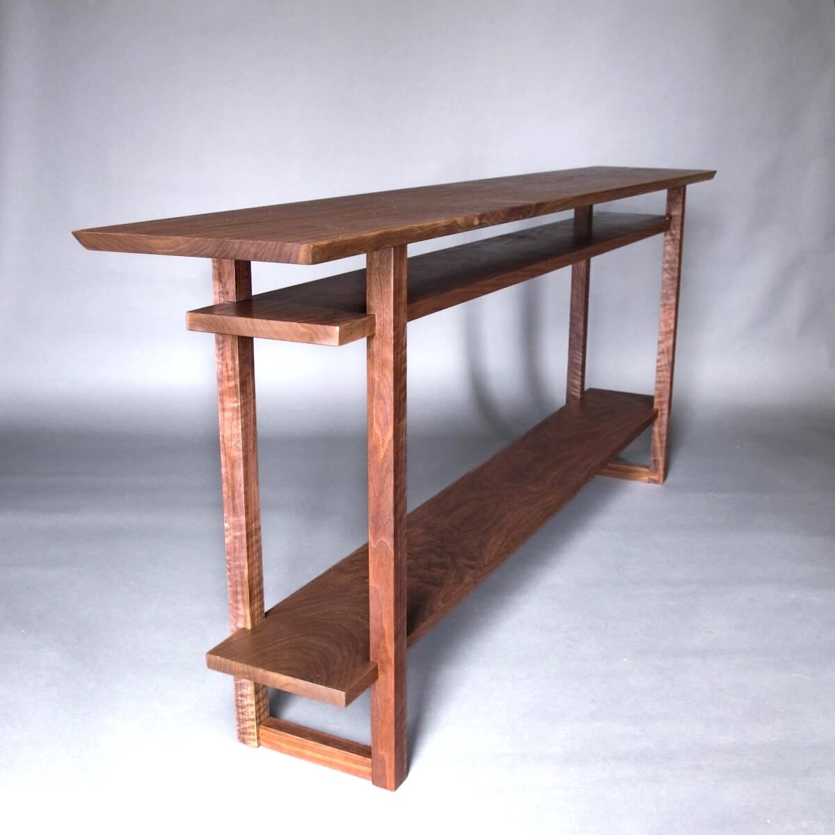 A long modern console table handcrafted from solid walnut wood for hallways and entryways by Mokuzai Furniture.