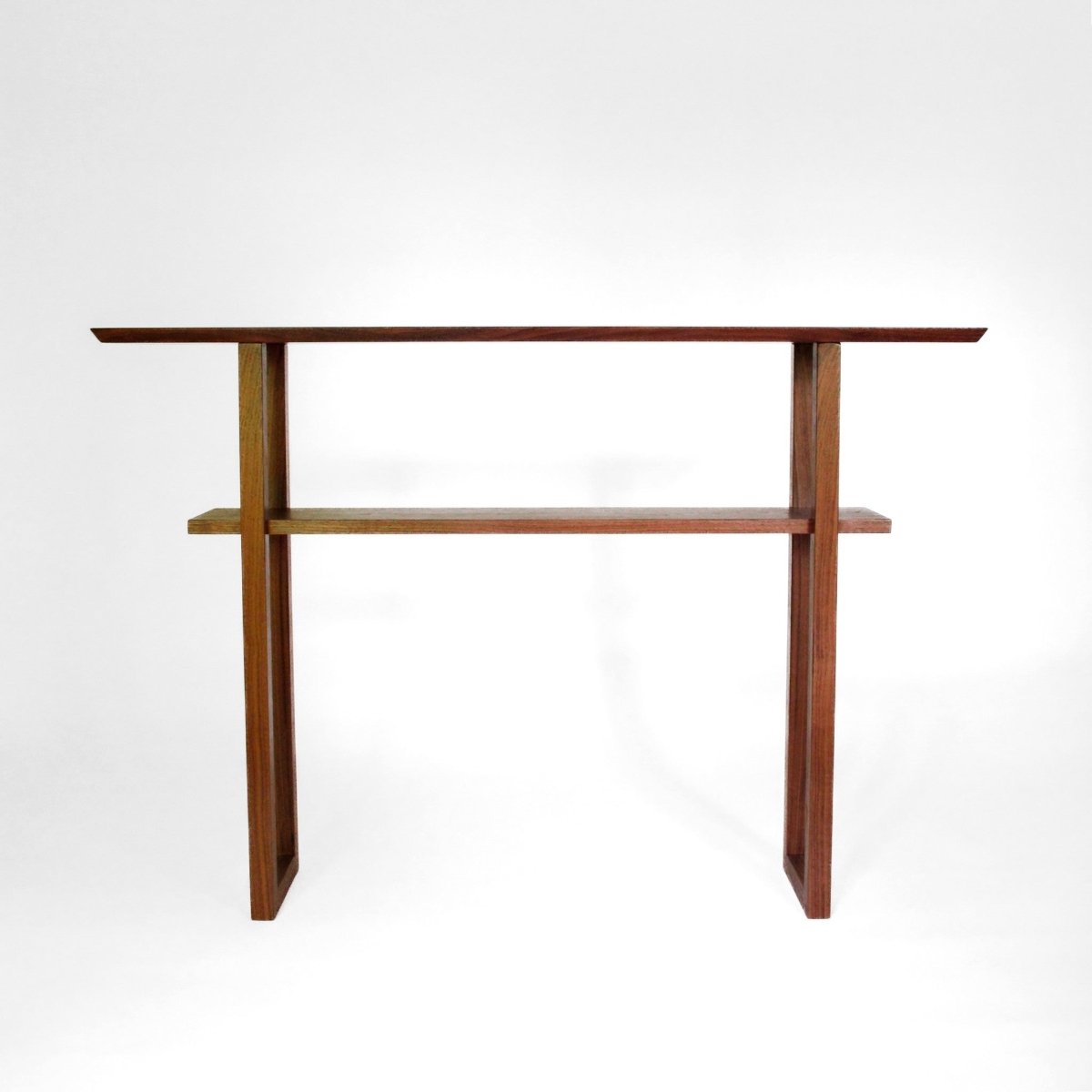 A narrow walnut sofa table with shelf by Mokuzai Furniture.