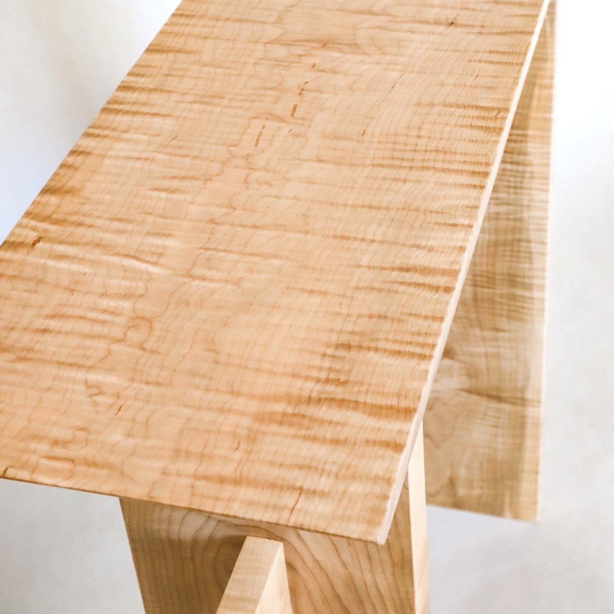 A view from above of the unique tiger maple wood grain pattern on a narrow side table from Mokuzai Furniture.