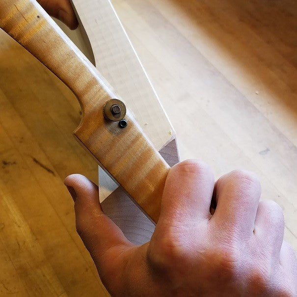 the furniture maker details the top corners of a side table at Mokuzai Furniture