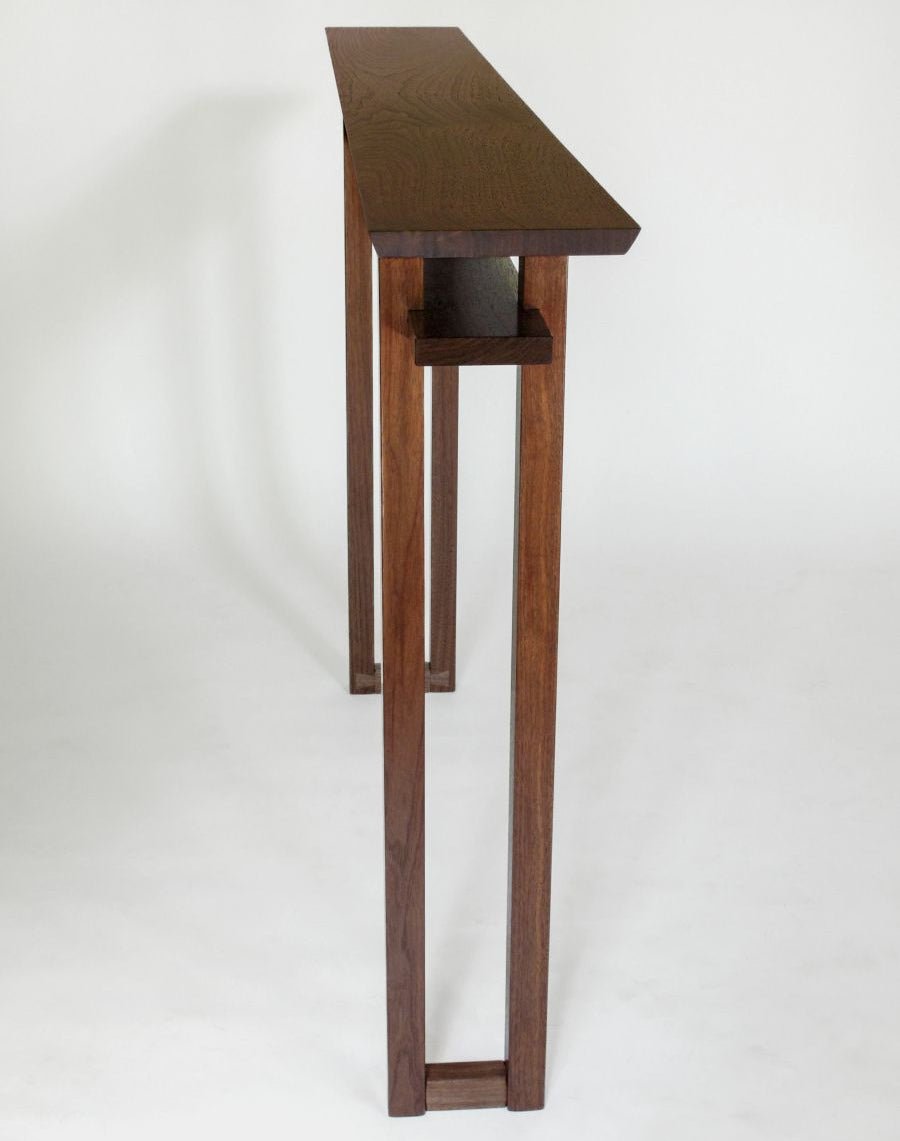 A very narrow entry way table with shelf, handcrafted from solid walnut by Mokuzai Furniture.