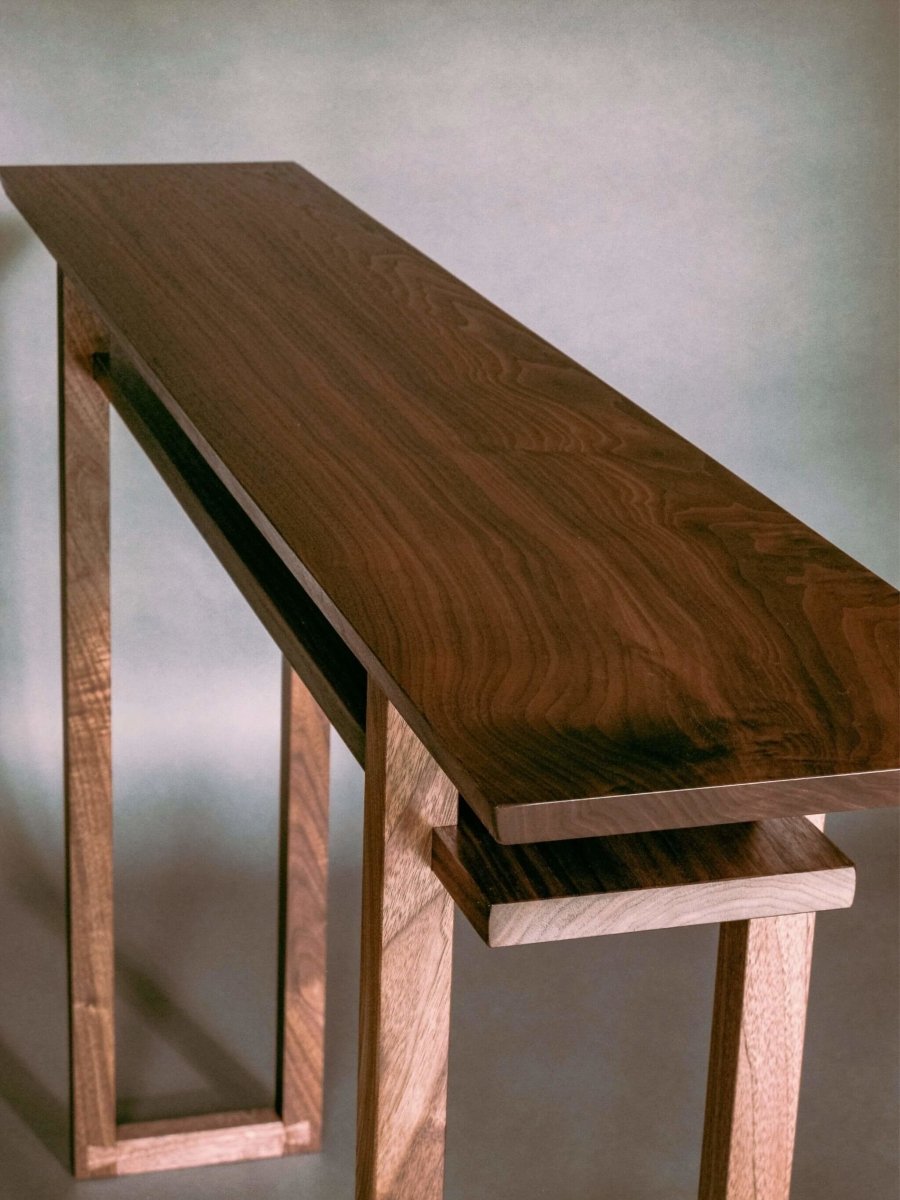 The Classic Console Table for hallways.  This walnut wood table design by Mokuzai Furniture, is a modern console table with shelf that works well for decorating small spaces