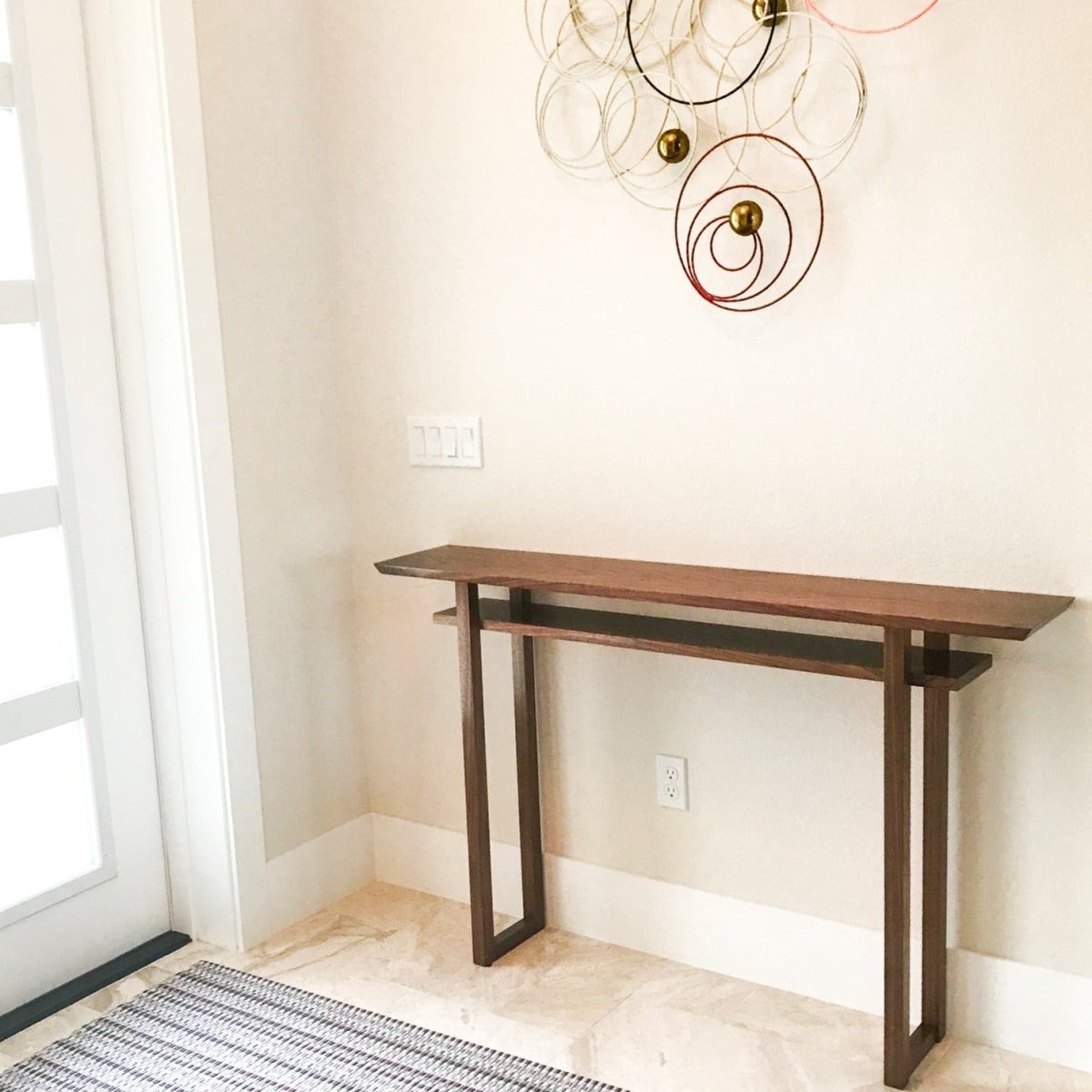 A contemporary entryway with a walnut entry console table by Mokuzai Furniture.