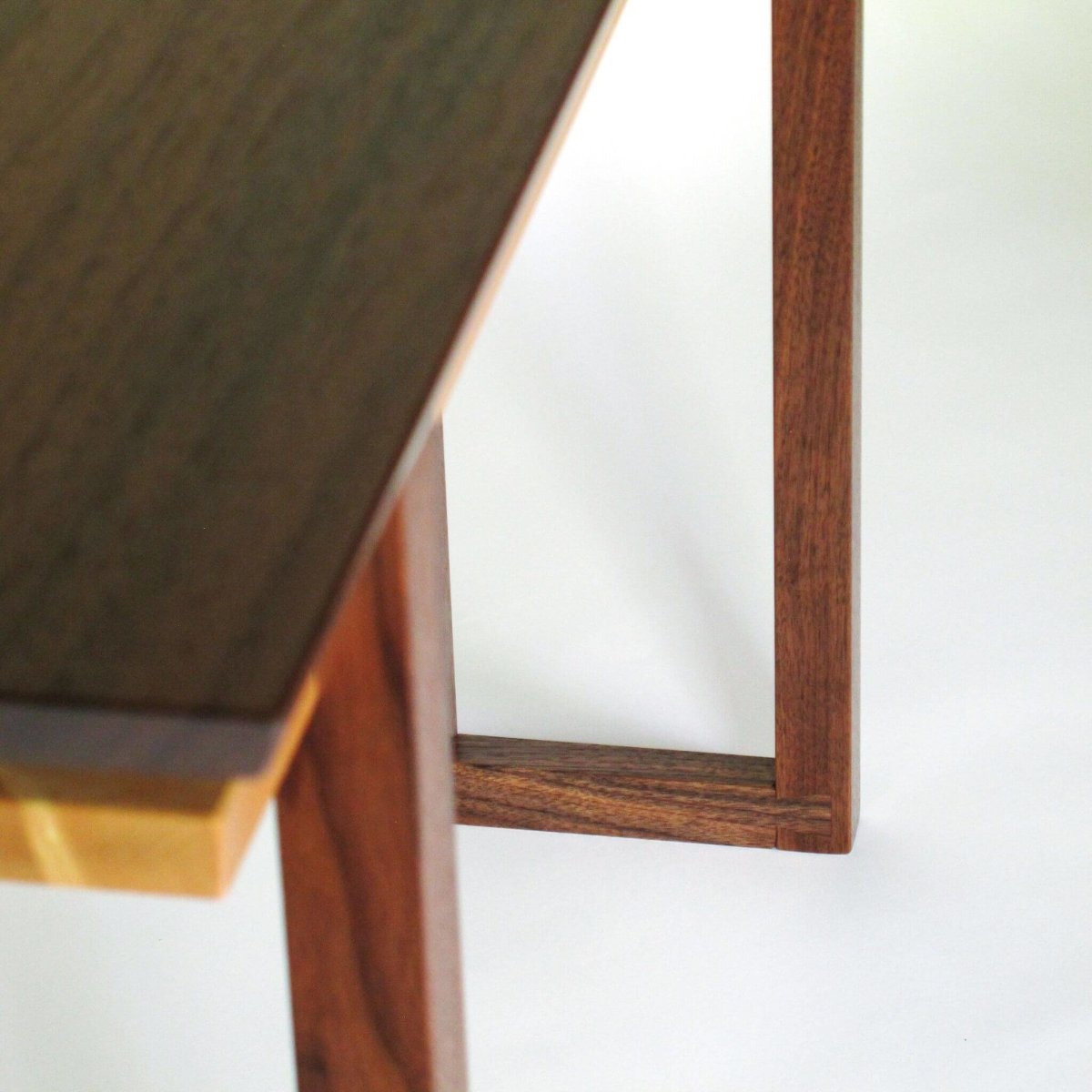 Our modern wood console tables feature unique details like these dovetail feet on our walnut and maple console table that is perfect for narrow hallway decorating.  Wood Furniture designs from Mokuzai Furniture