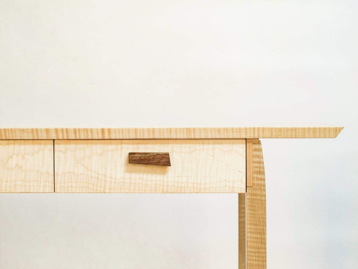 hand-shaped drawer pulls in contrasting walnut on this tiger maple console table