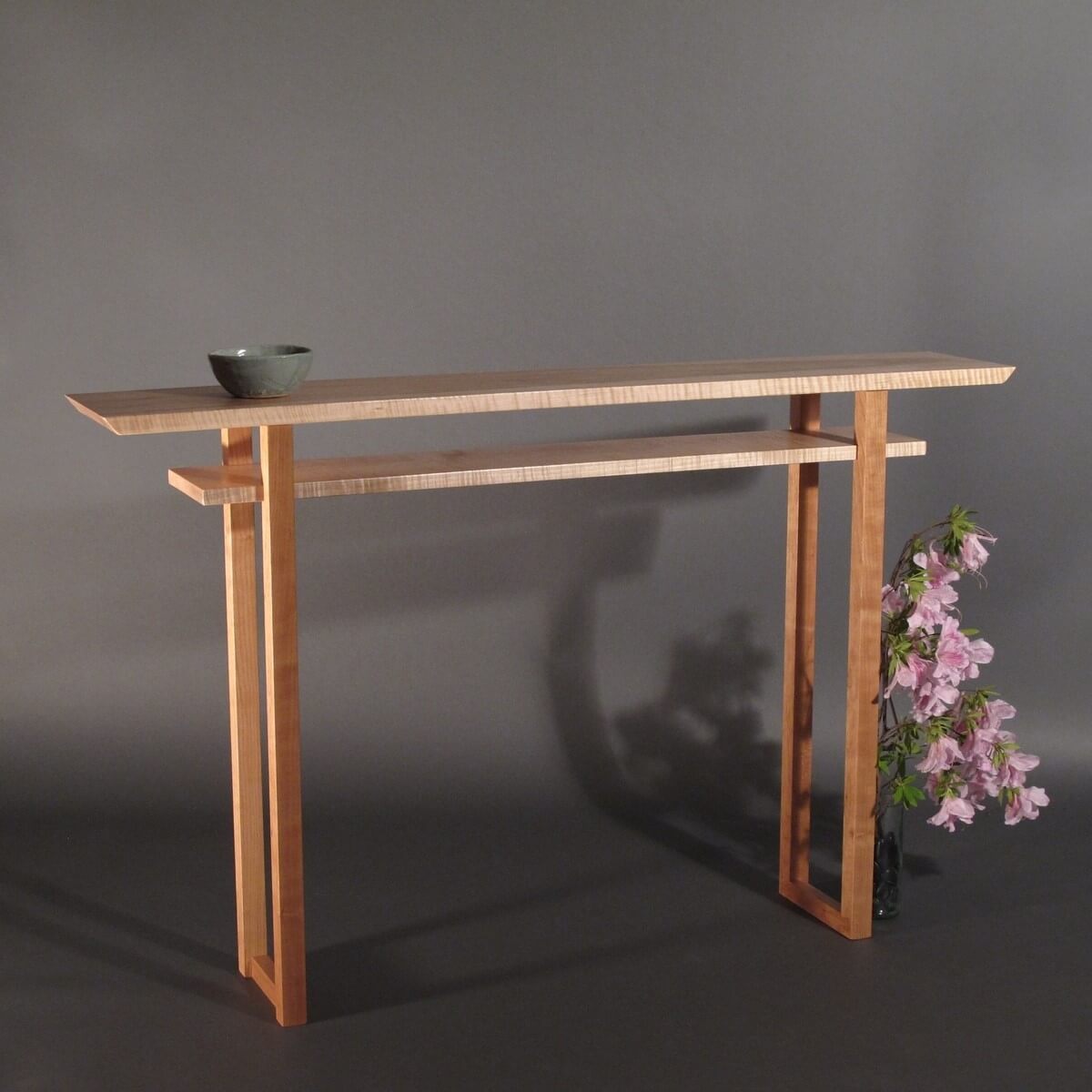 A minimalist hallway console table hand-crafted from tiger maple and cherry wood.  Furniture designs from Mokuzai Furniture