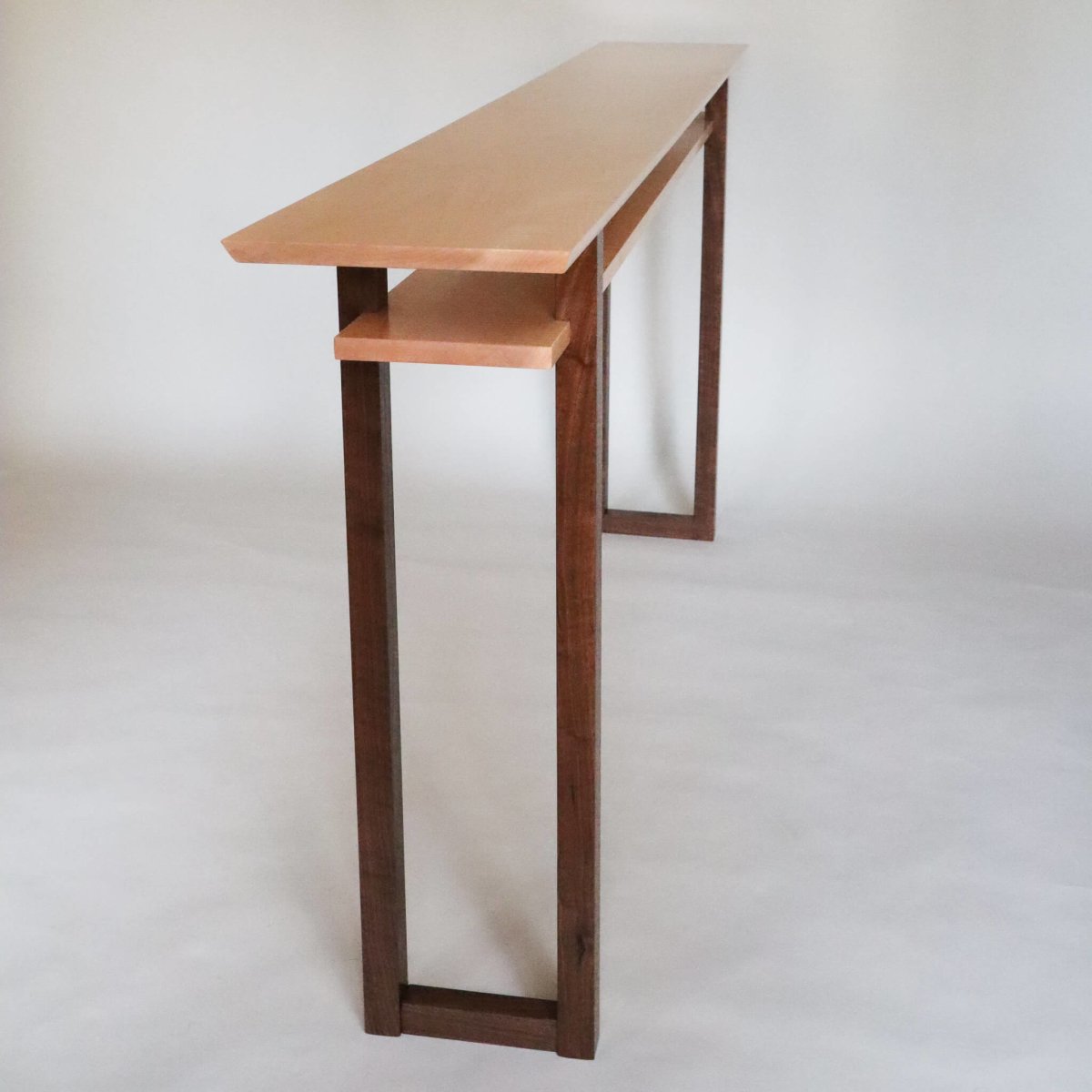 A long narrow table for entryways, this tiger maple and walnut console table is hand-crafted from premium wood and features lovely craftsmanship details.  Fine furniture designs from Mokuzai Furniture