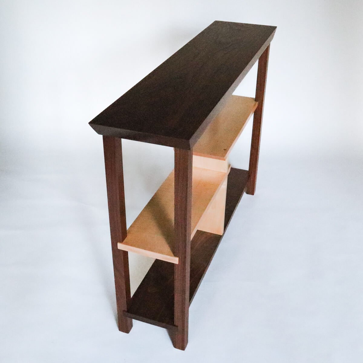 a narrow side table console in walnut wood with tiger maple shelves by Mokuzai Furniture