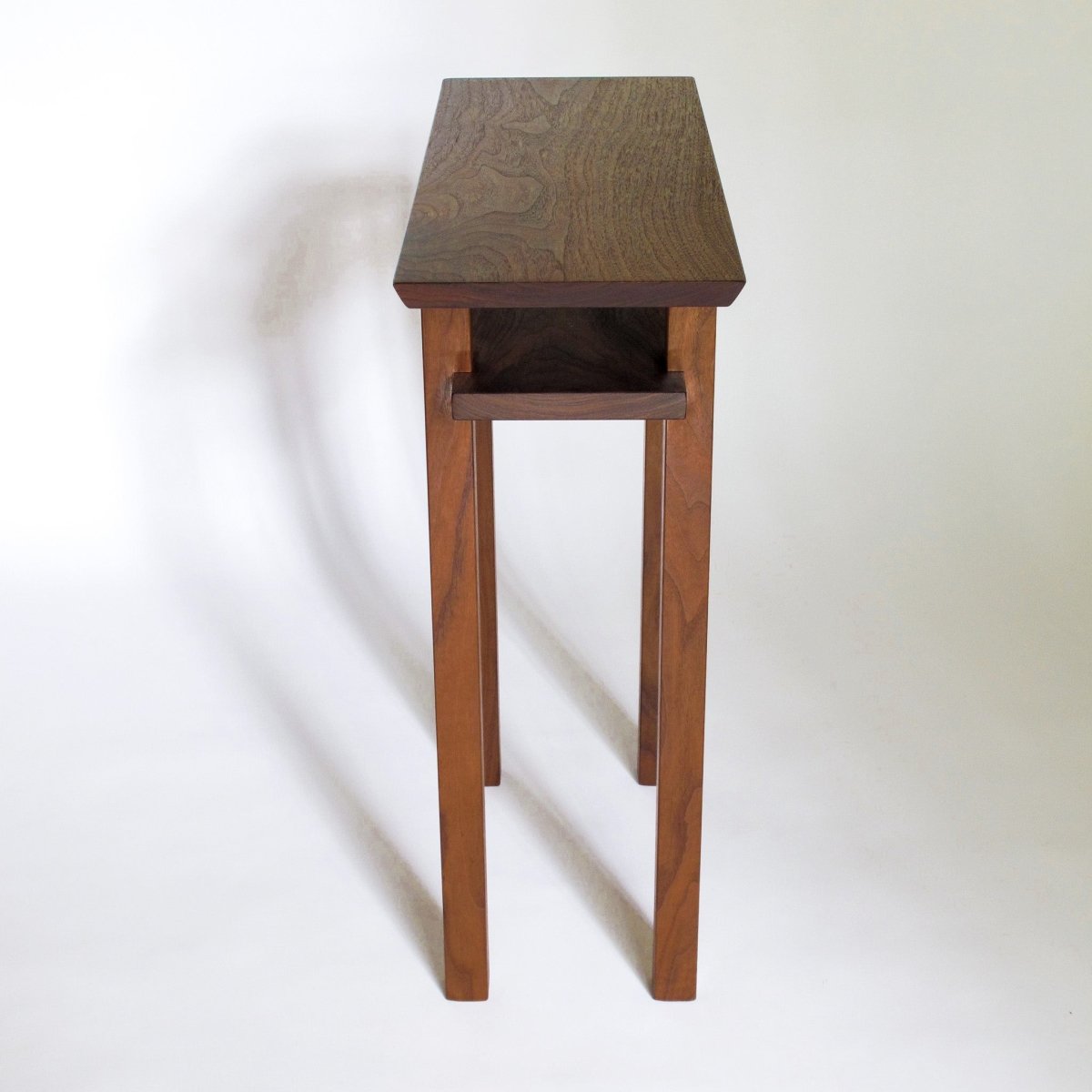 A skinny end table in solid walnut, hand-crafted by furniture artists at Mokuzai Furniture- modern wood furniture designs for small spaces