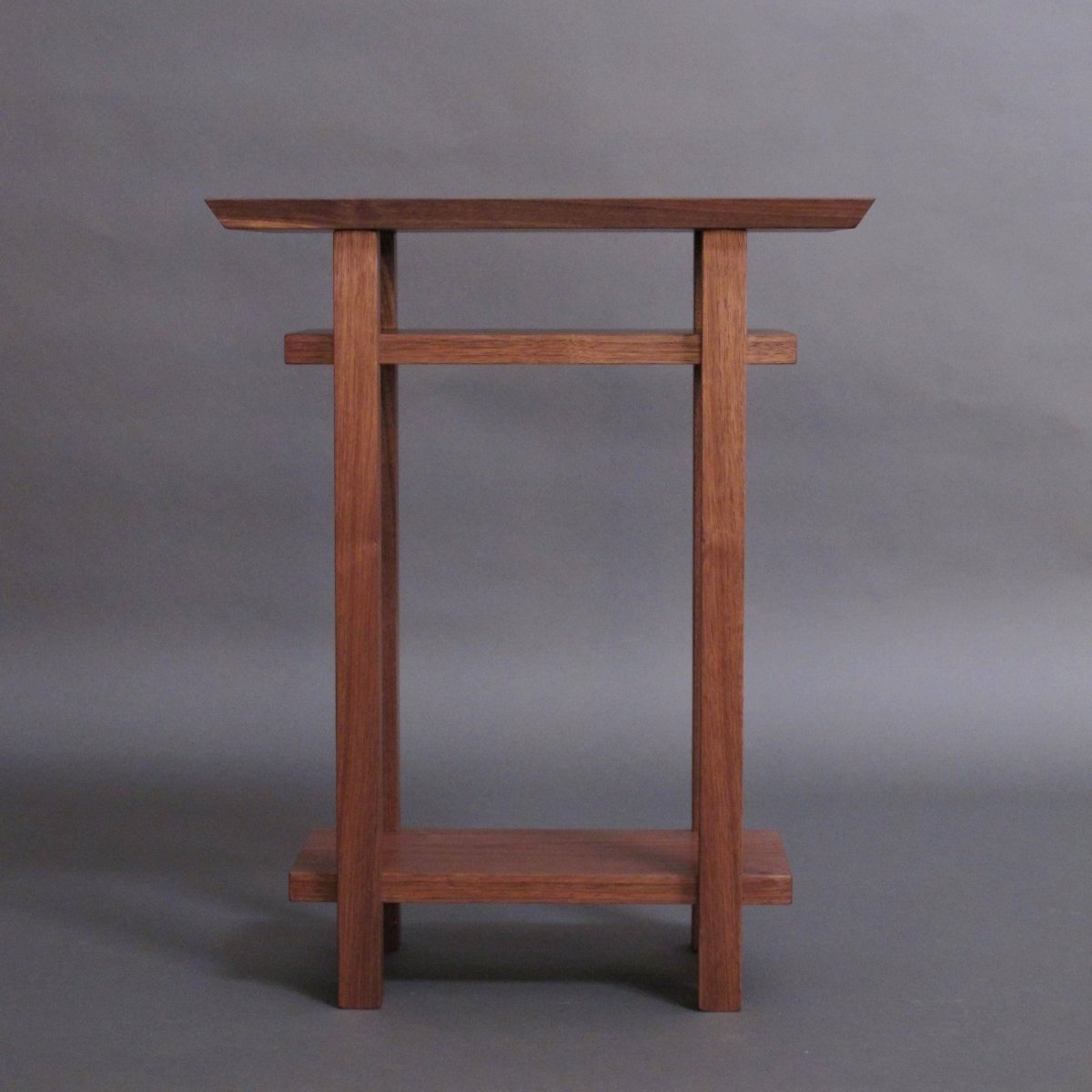 A small walnut end table with shelves hand-crafted by furniture artists at Mokuzai Furniture.  This small end table adds beauty and function to even the smallest spaces.