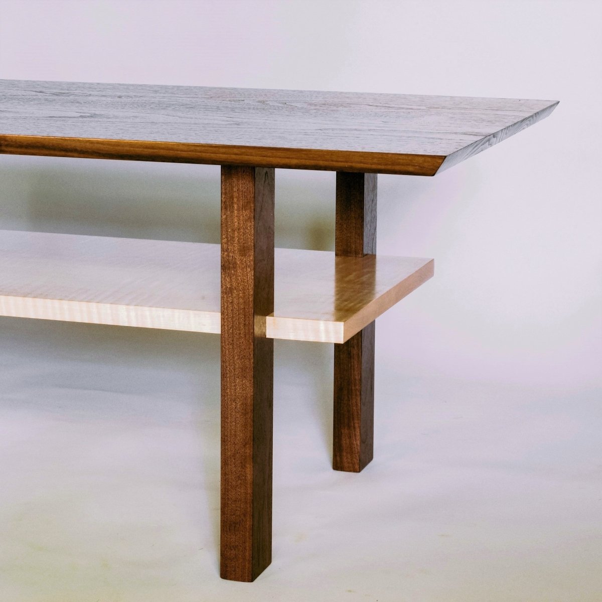 A minimalist wood coffee table design by Mokuzai Furniture - walnut and tiger maple coffee table with shelf