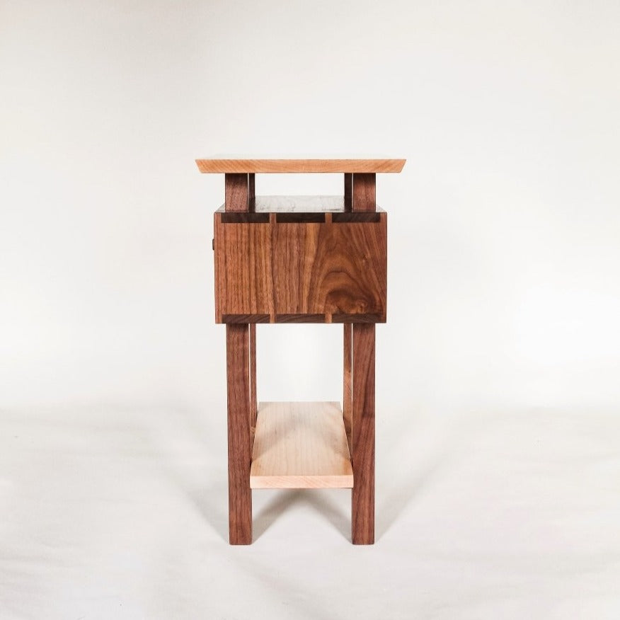 A narrow table with drawer, side view of dovetail details and shelf