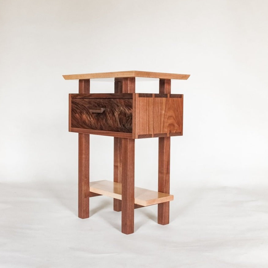A small narrow nightstand made from walnut and tiger maple