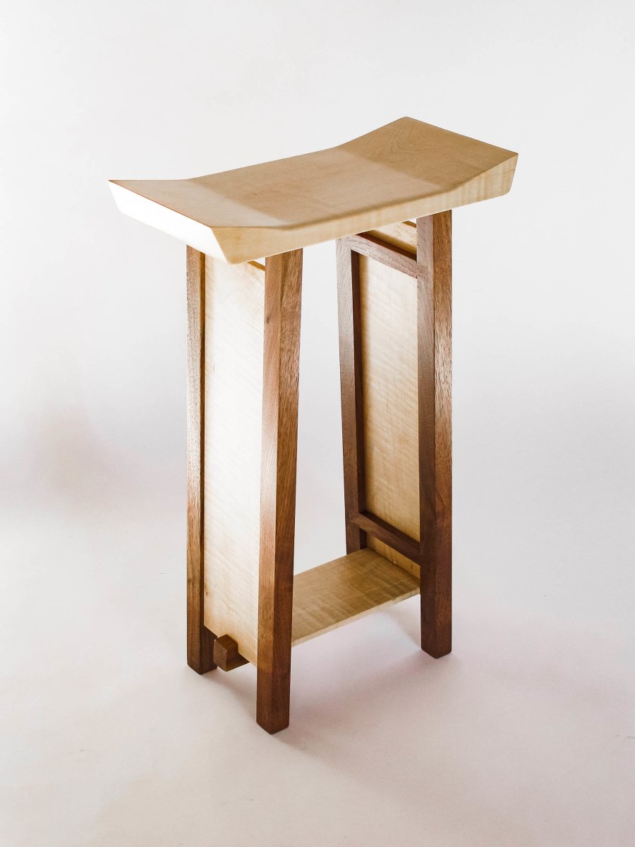 a narrow side table in tiger maple and walnut by Mokuzai Furniture