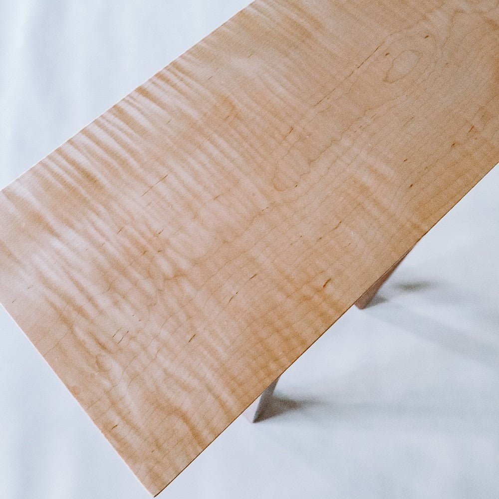 A tiger maple table top on a tall entry table by Mokuzai Furniture.