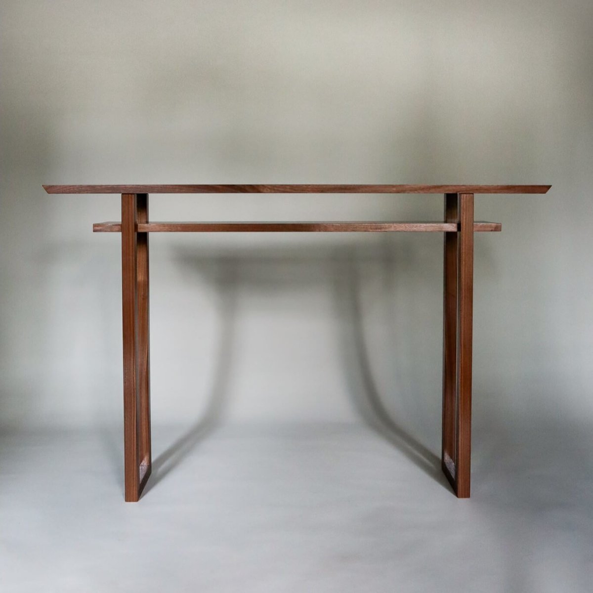A walnut console table with shelf by Mokuzai Furniture.  Designed for narrow hallways decorating, this modern console table is made from premium walnut wood.
